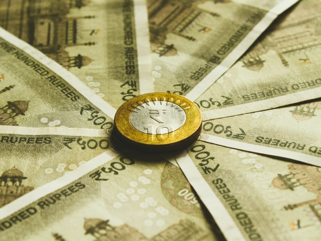 Indian rupee banknotes arranged around a coin